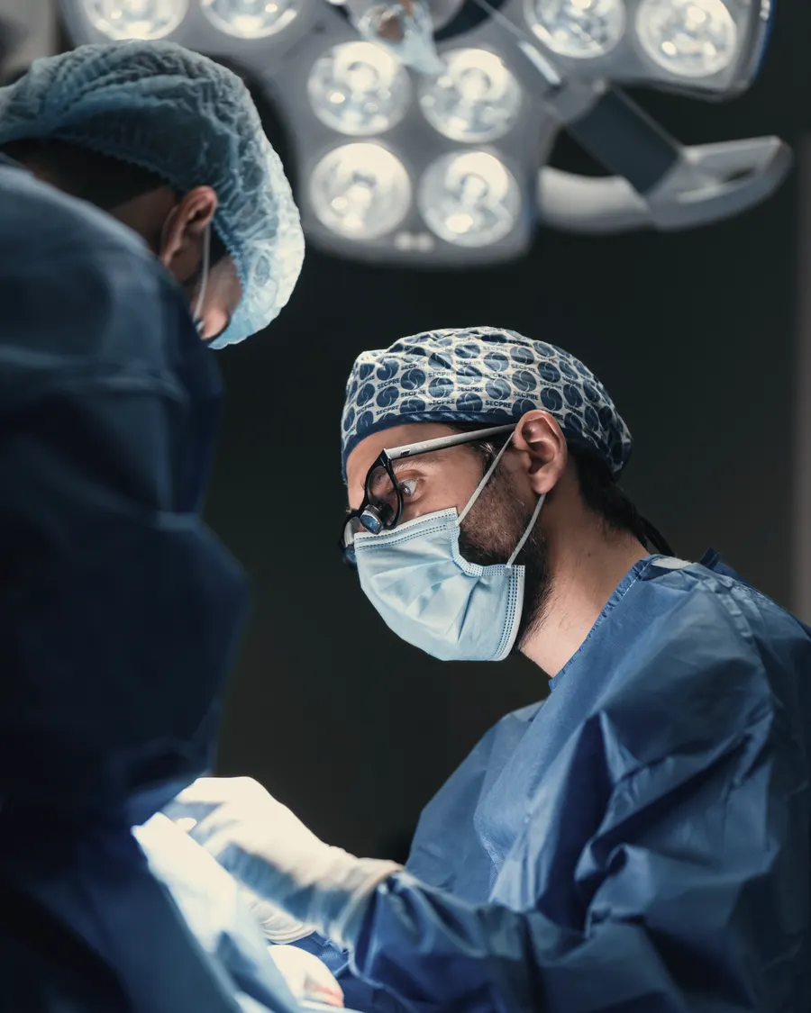 Dr. Manuel Robustillo operando con lupas quirúrgicas